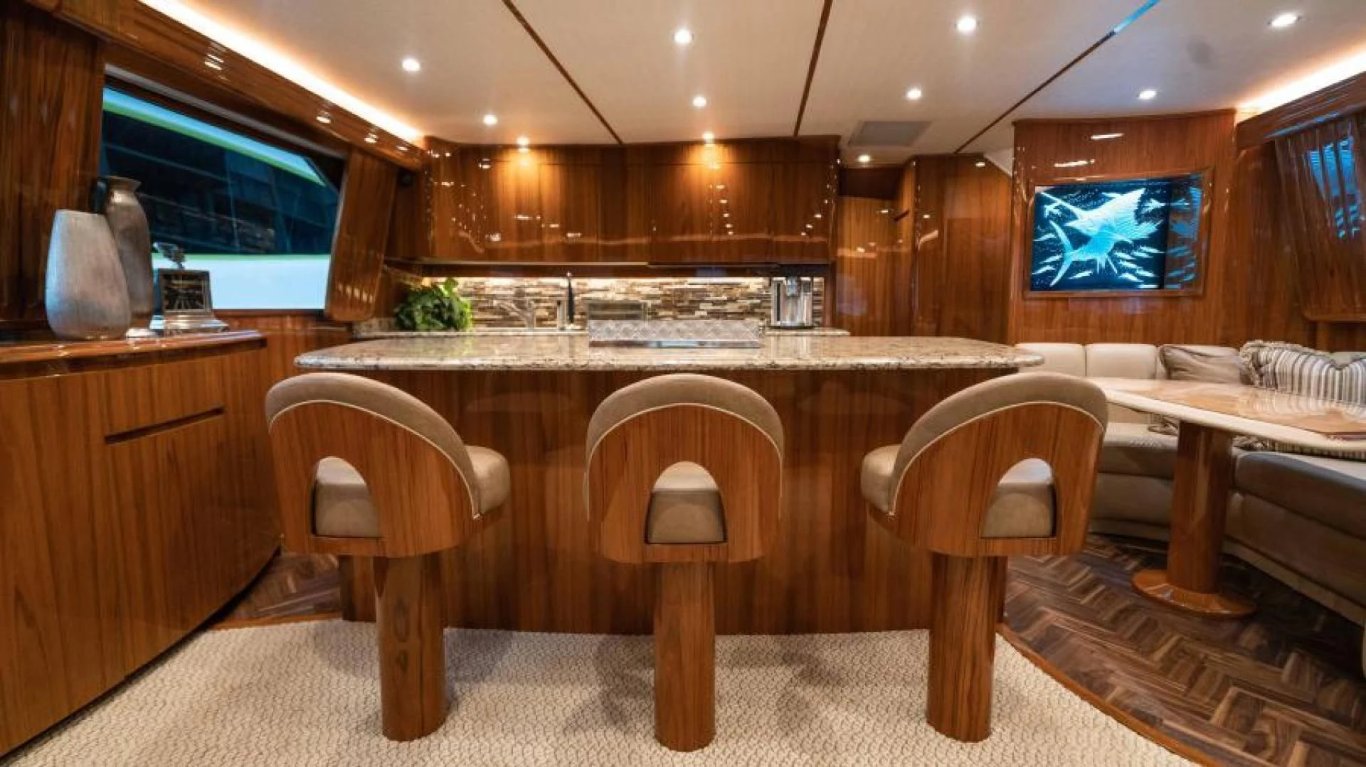 a large kitchen with a bar and chairs aboard NEVER TOO LATE Yacht for Charter