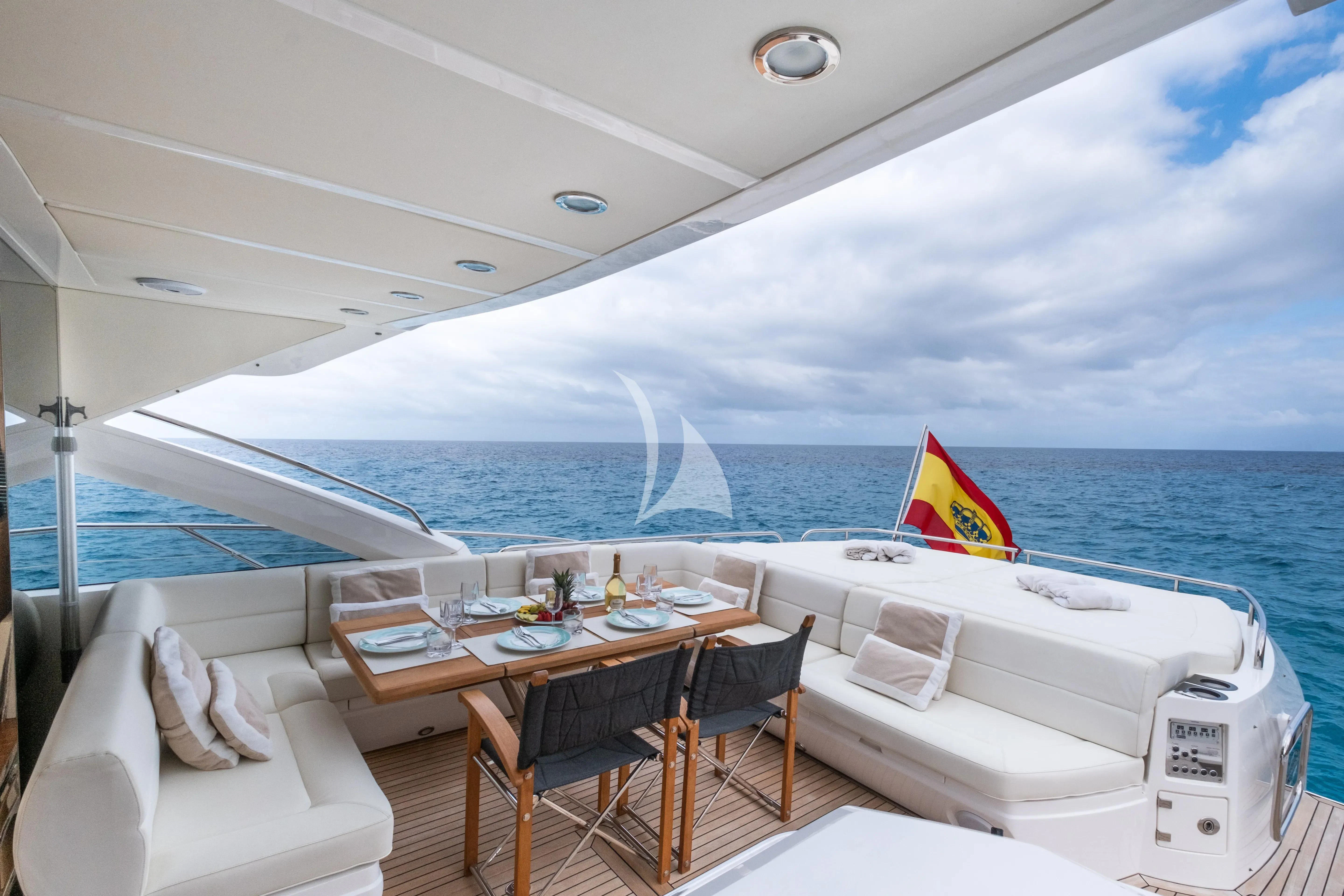 a boat with a table and chairs on the deck aboard NEVER TOO LATE Yacht for Charter