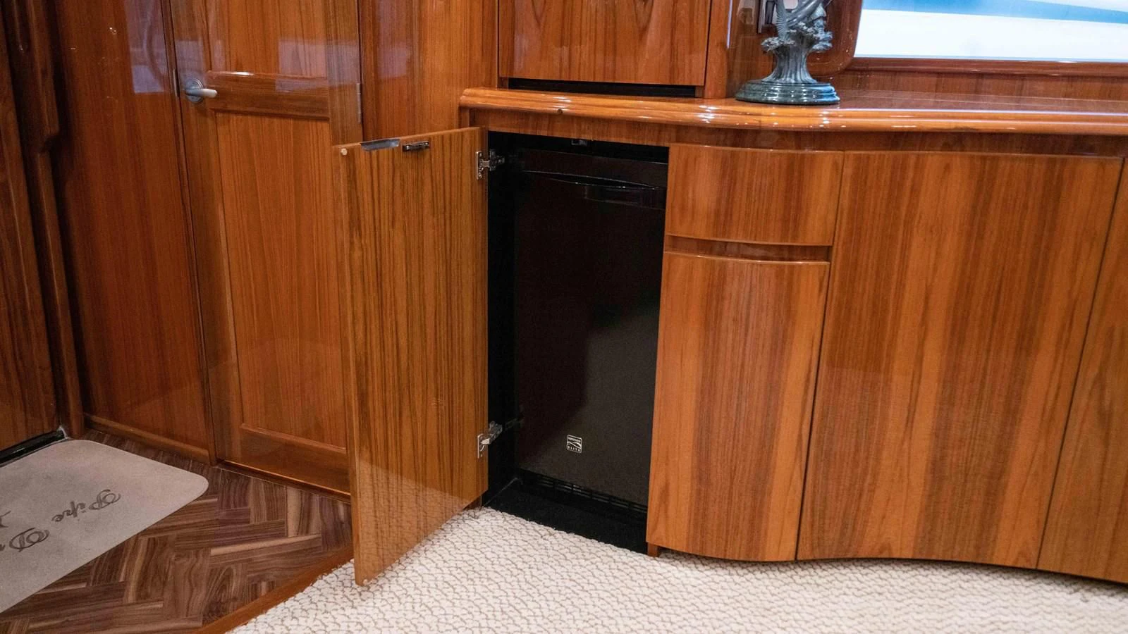 a wooden cabinet with a black door aboard NEVER TOO LATE Yacht for Charter