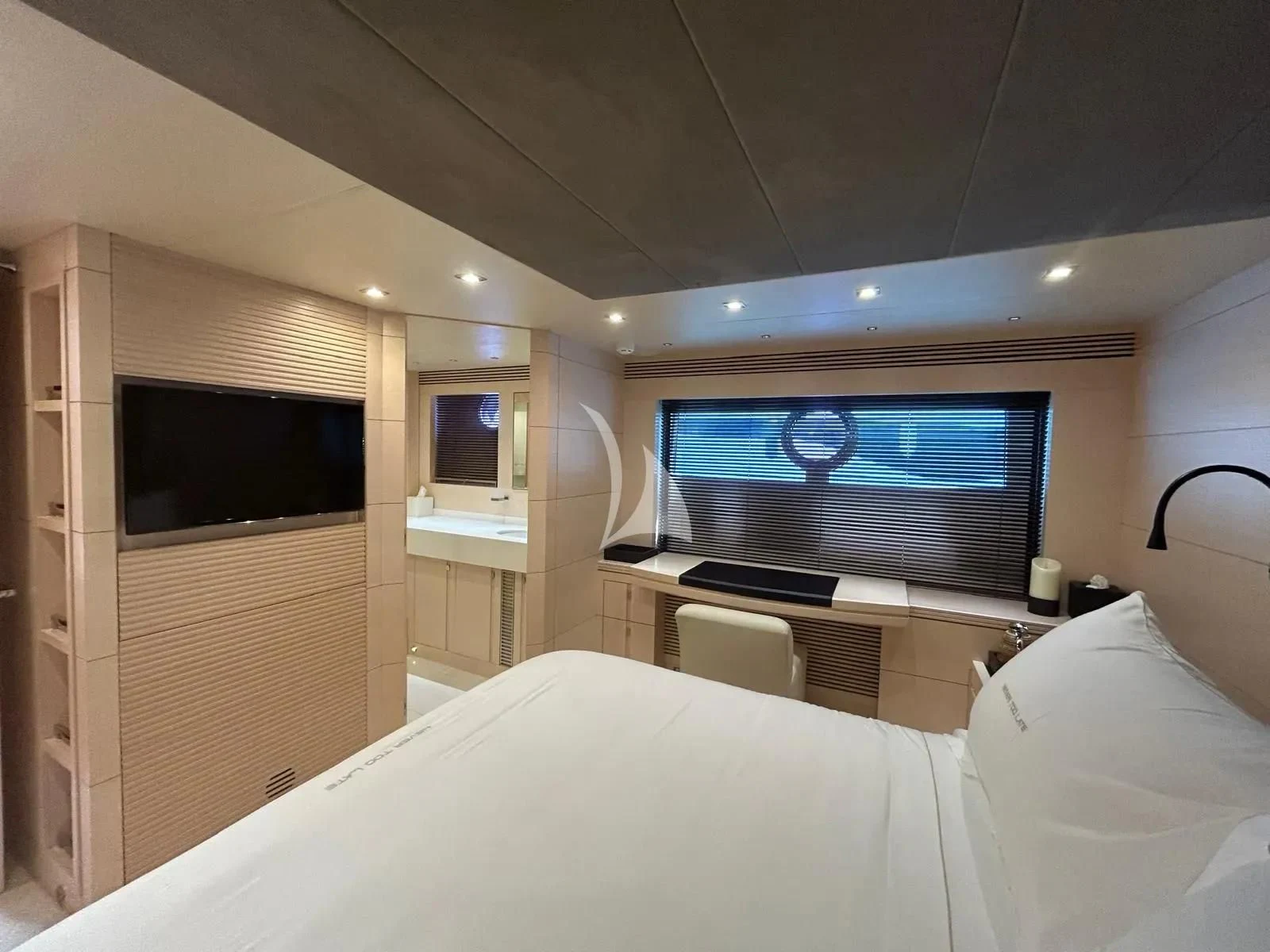 a bedroom with a large television aboard NEVER TOO LATE Yacht for Charter