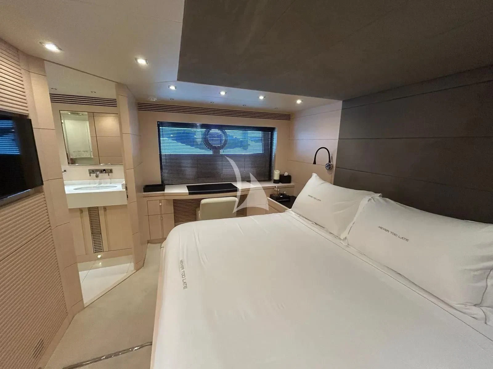 a room with a bed and a tv on the wall aboard NEVER TOO LATE Yacht for Charter