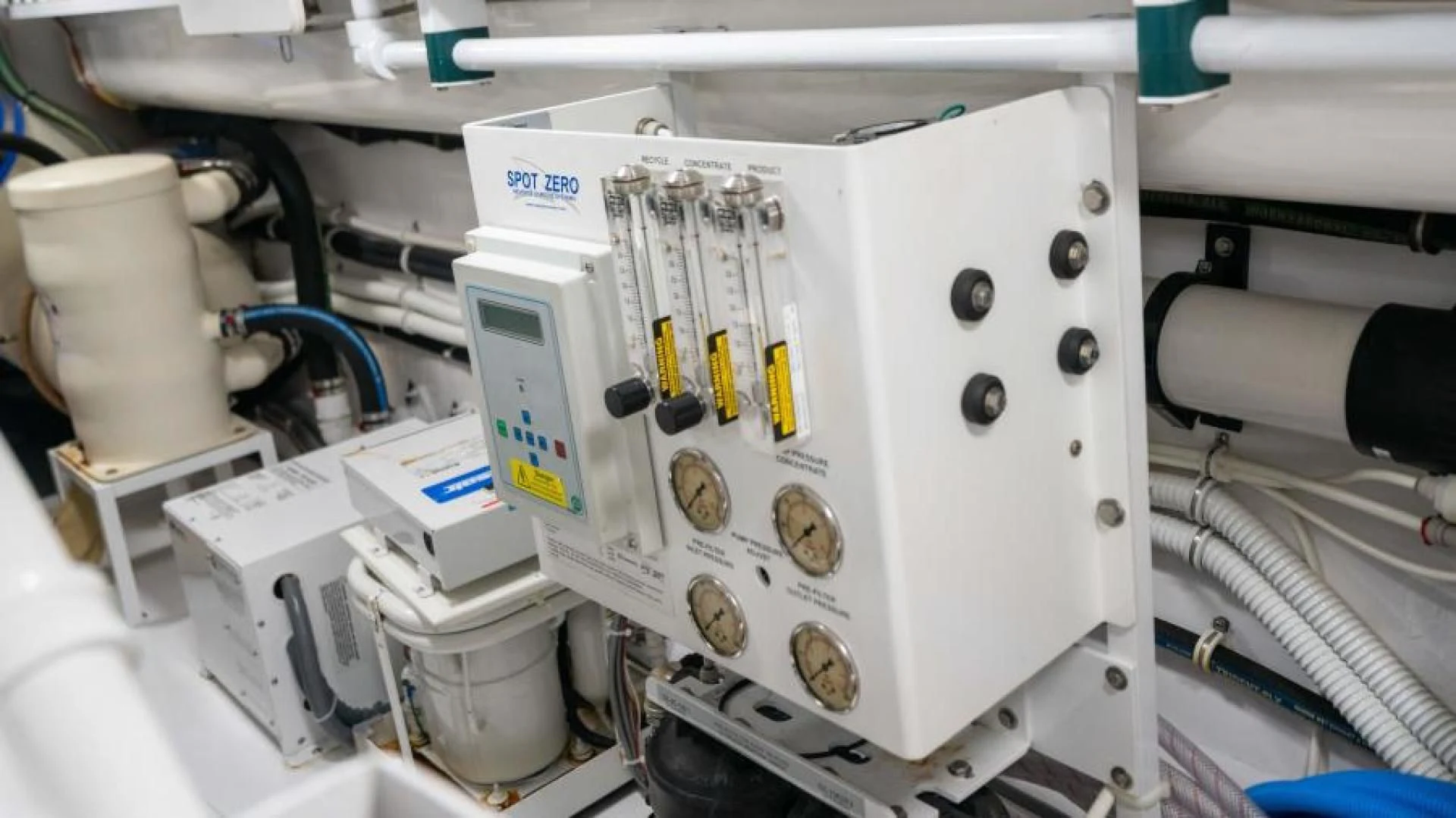 a white machine with a blue and yellow label aboard NEVER TOO LATE Yacht for Charter