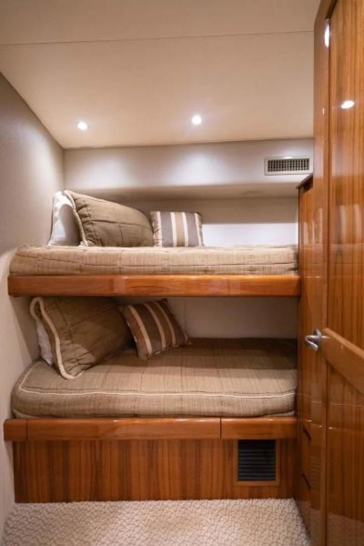 a bed with a wooden frame aboard NEVER TOO LATE Yacht for Charter