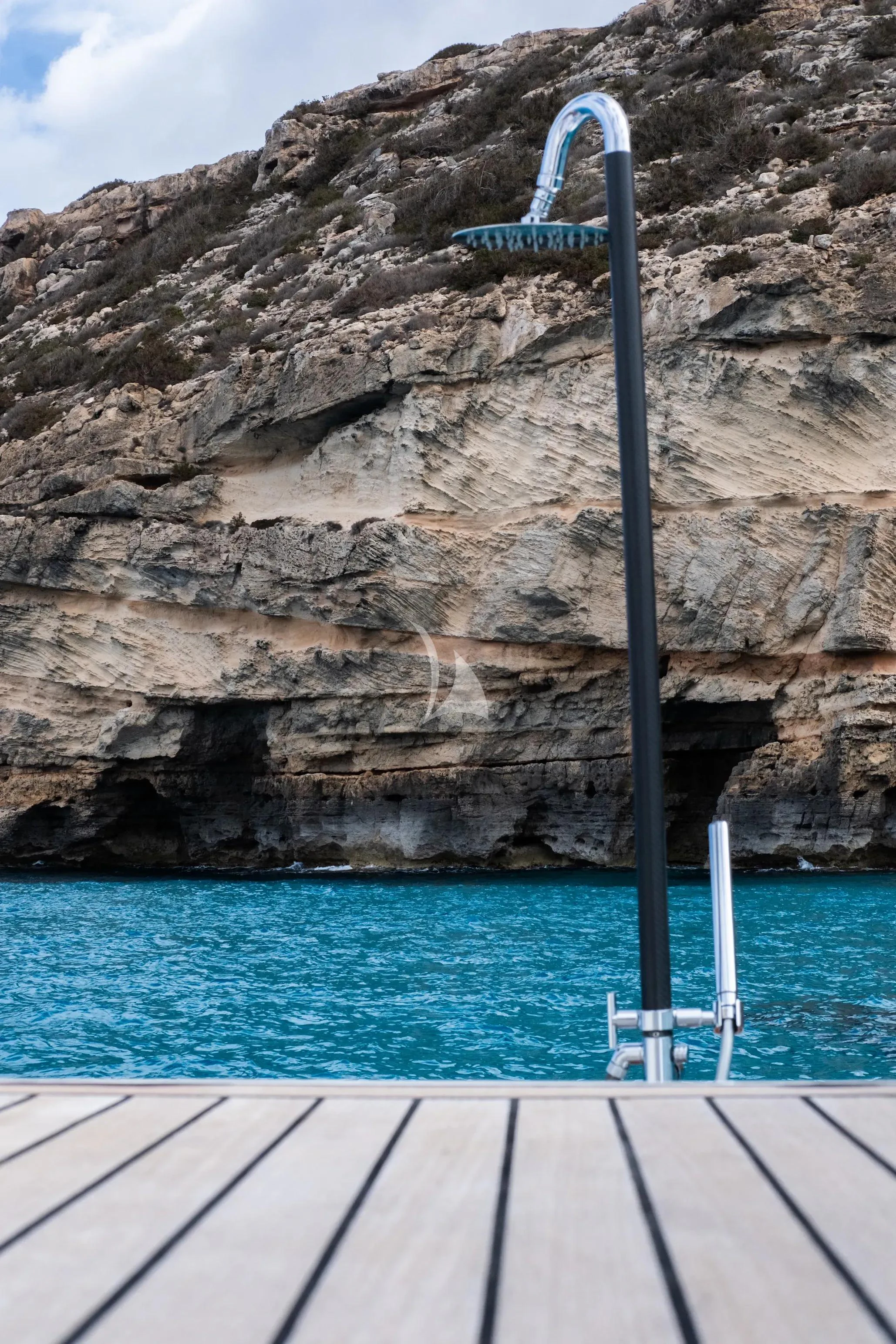 a large rock cliff with a sign on it aboard NEVER TOO LATE Yacht for Charter