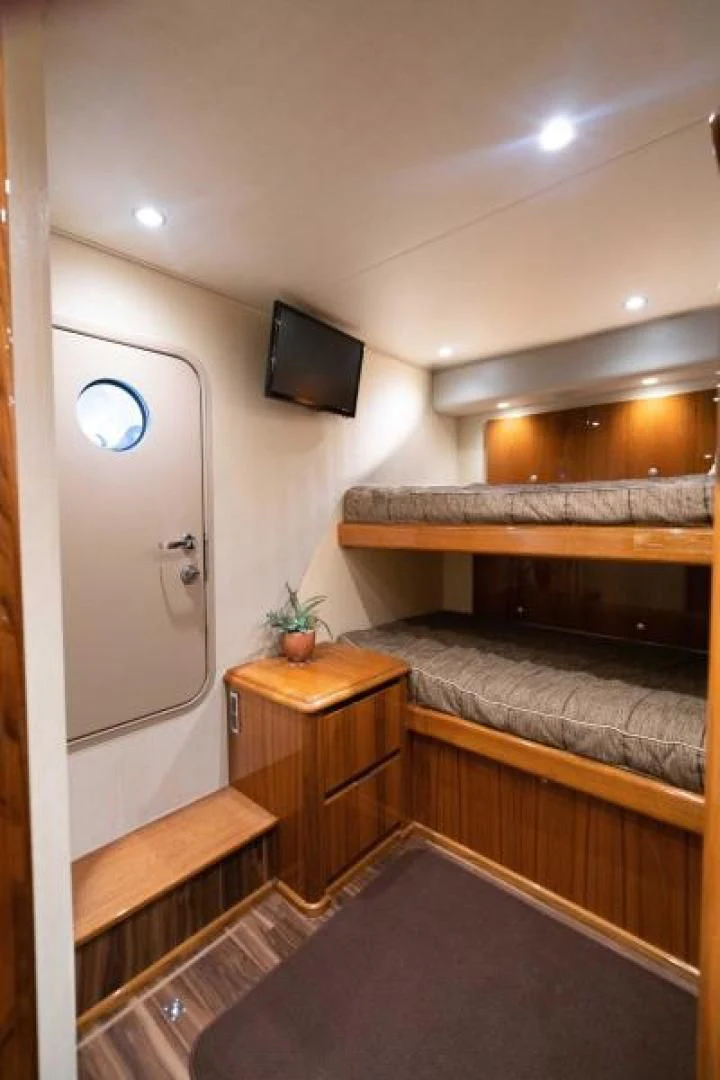 a bedroom with a bed and tv aboard NEVER TOO LATE Yacht for Charter