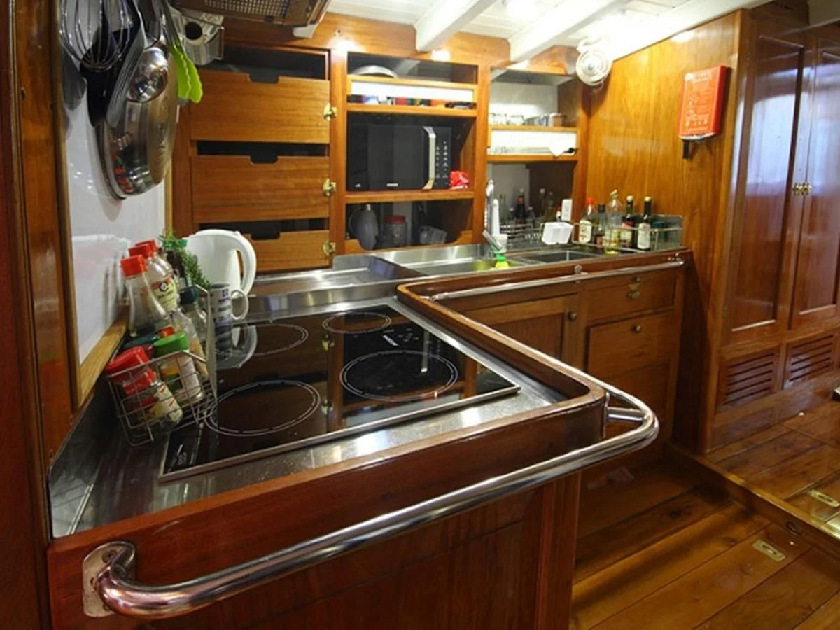 a kitchen with wooden cabinets aboard AVENTURE Yacht for Sale