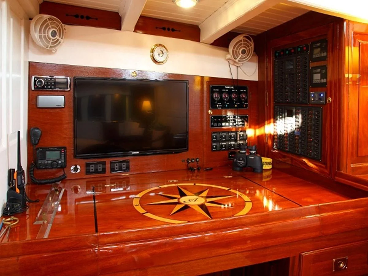 a tv on a stand in a room with a wood floor aboard AVENTURE Yacht for Sale