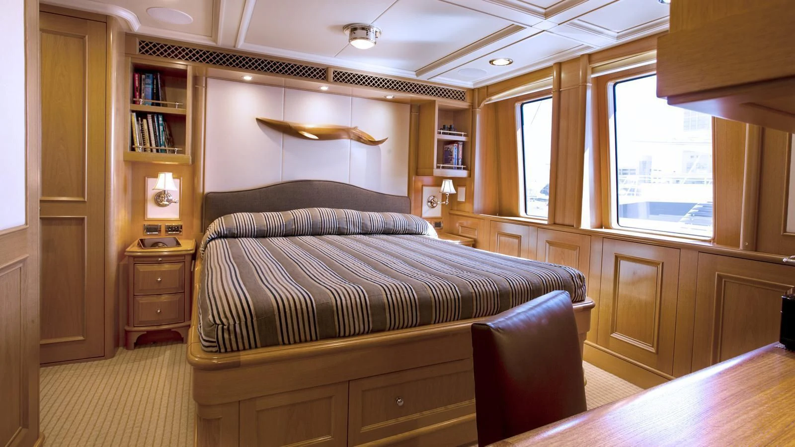 a bedroom with a bed and a bookcase aboard ONIKA Yacht for Sale