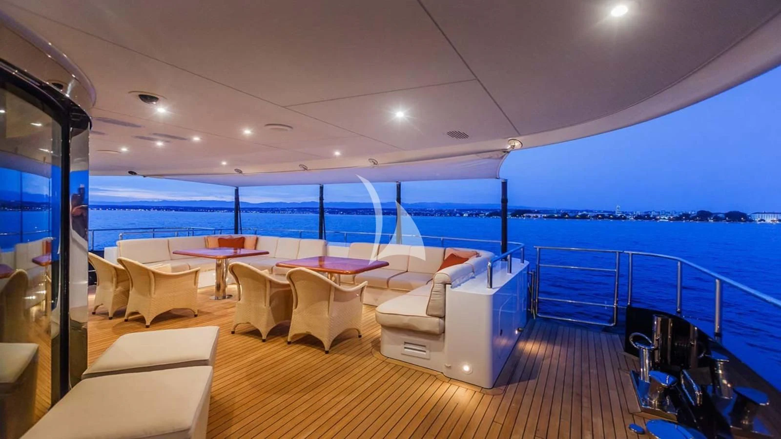 a room with a table and chairs and a large body of water aboard AGRAM Yacht for Charter