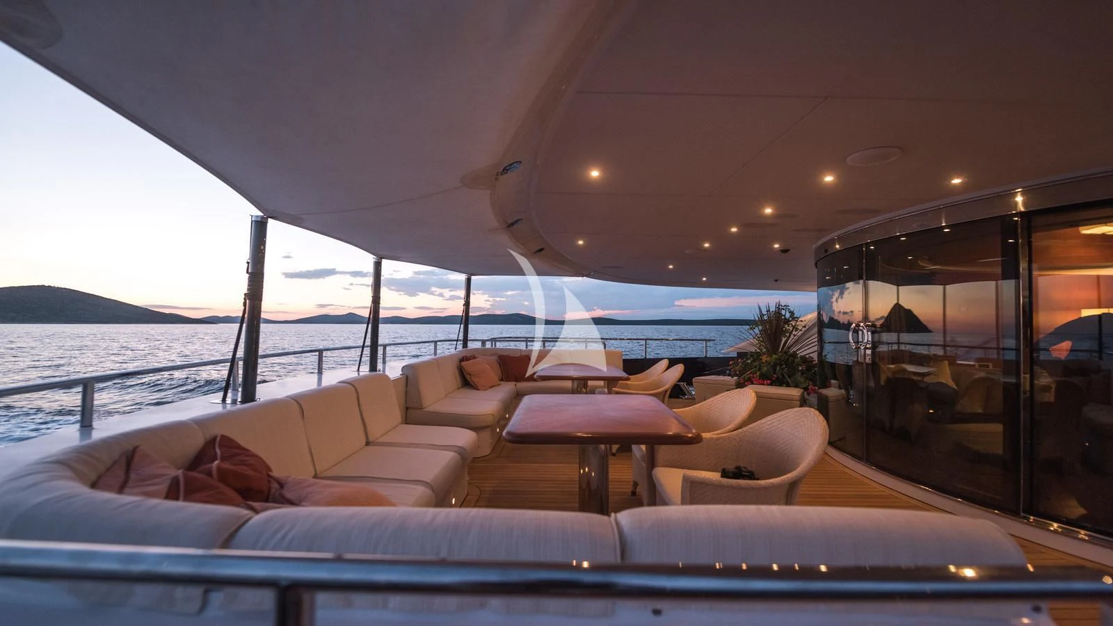 a large lounge area with a large glass window overlooking a body of water aboard AGRAM Yacht for Charter