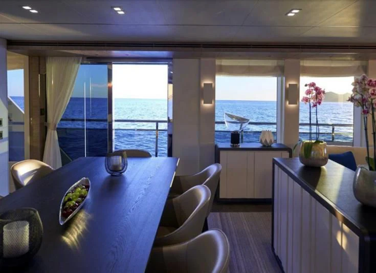 a room with a table and chairs aboard AMAN Yacht for Sale