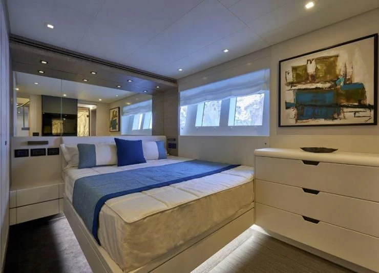 a room with a bed and a dresser aboard AMAN Yacht for Sale