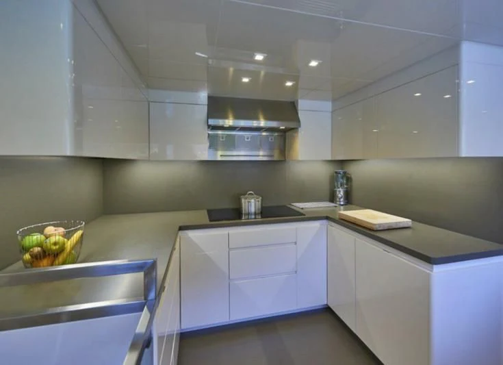 a kitchen with white cabinets aboard AMAN Yacht for Sale