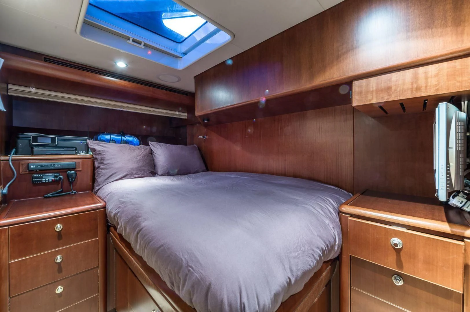 a bed with a wooden headboard aboard WINDWARD Yacht for Charter