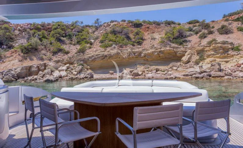 a table and chairs in front of a large body of water aboard WINDWARD Yacht for Charter