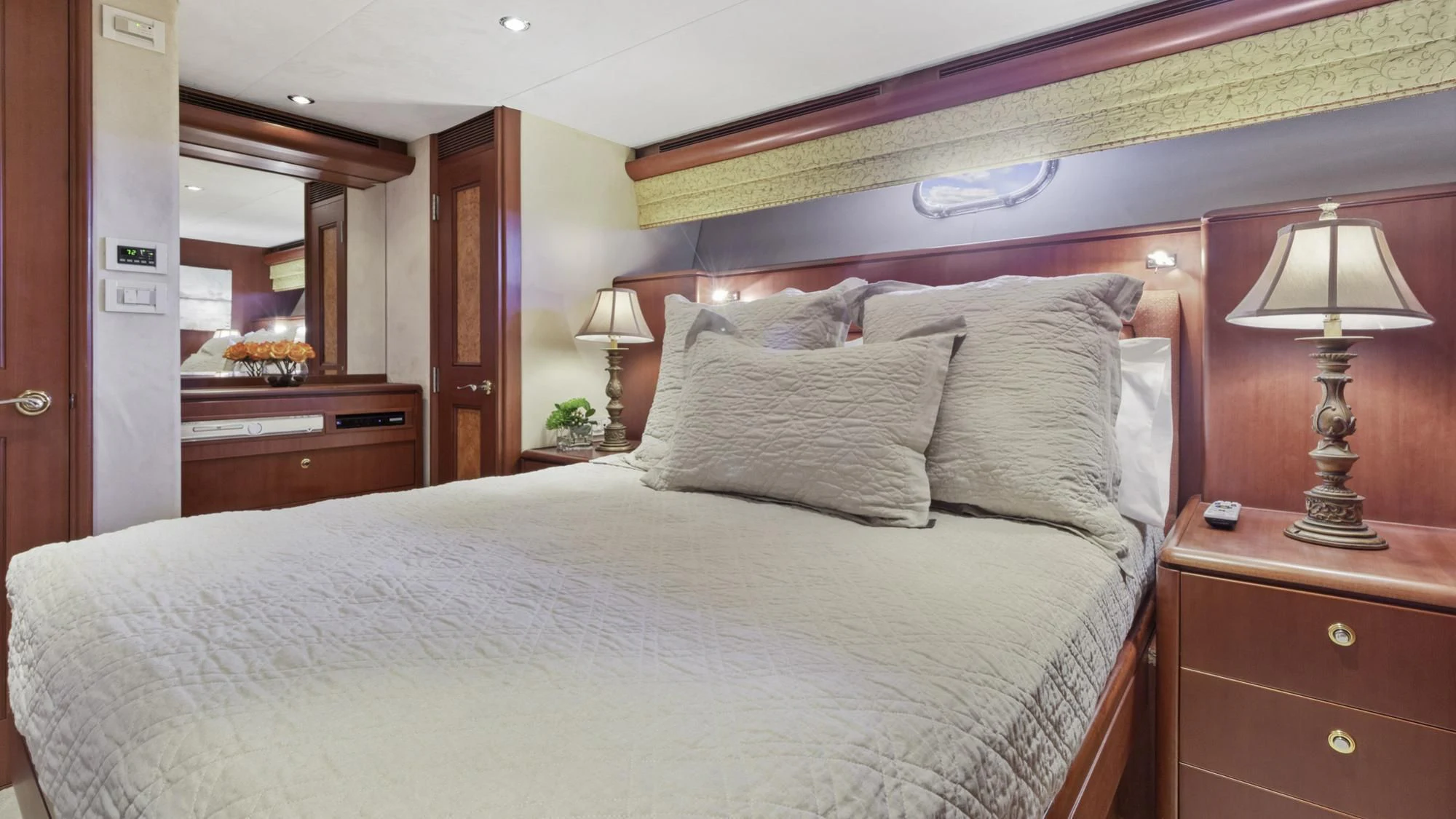 a bed with a white comforter aboard WINDWARD Yacht for Charter