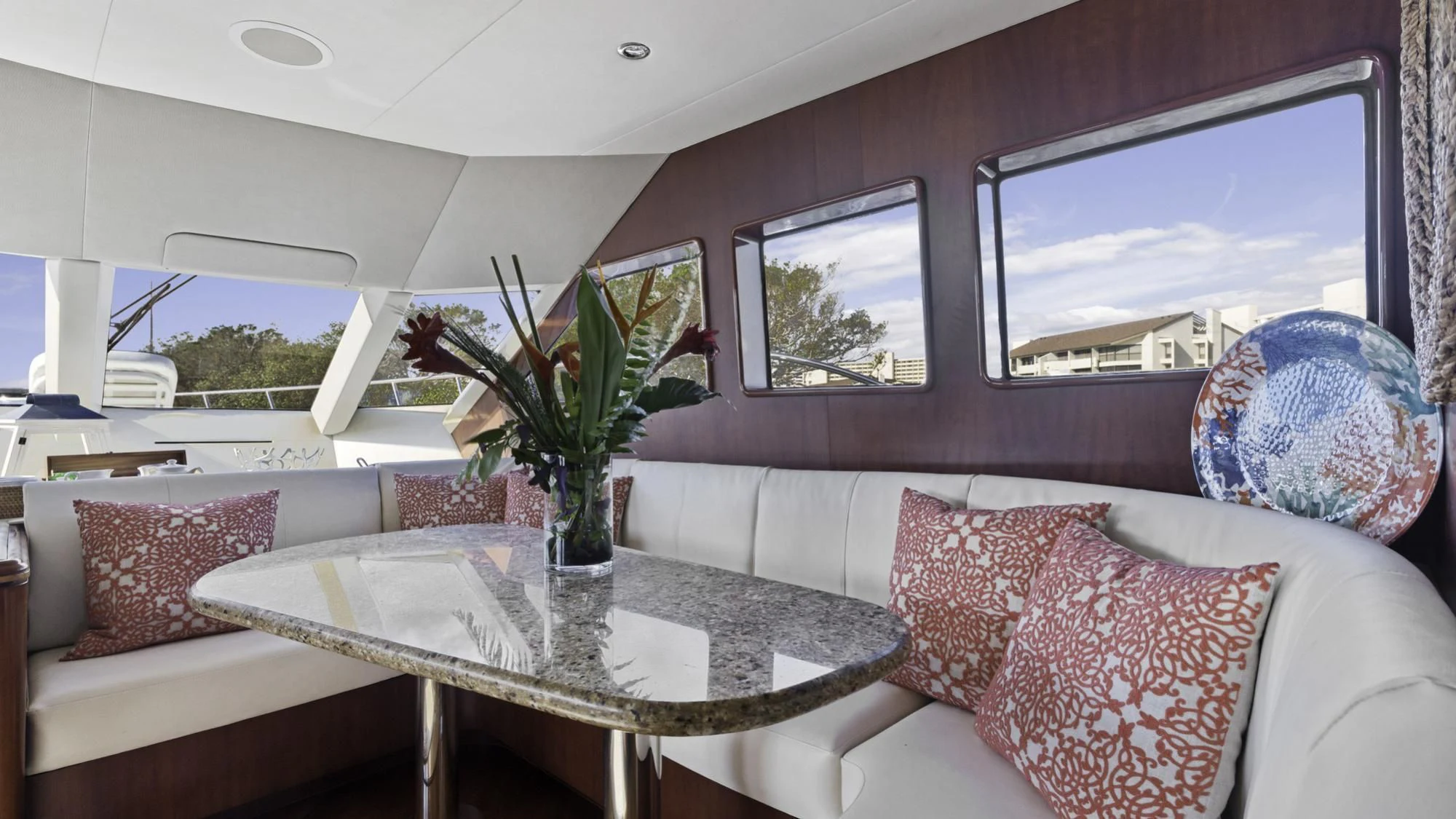 a living room with a white couch and a round table with a vase of flowers on it aboard WINDWARD Yacht for Charter