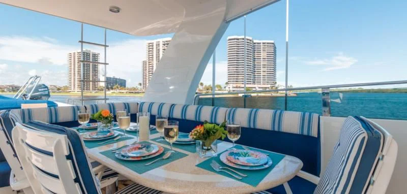 a table set for a meal on a deck overlooking a city aboard WINDWARD Yacht for Charter