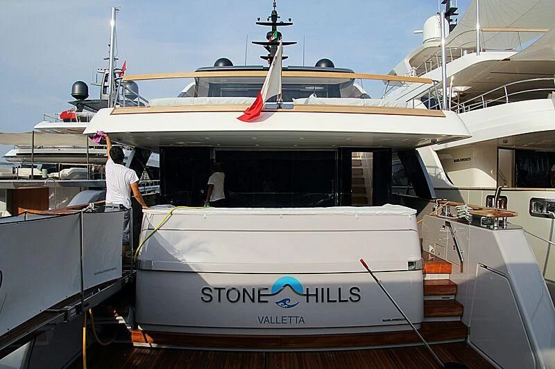 a person standing next to a boat aboard STONE HILLS Yacht for Sale