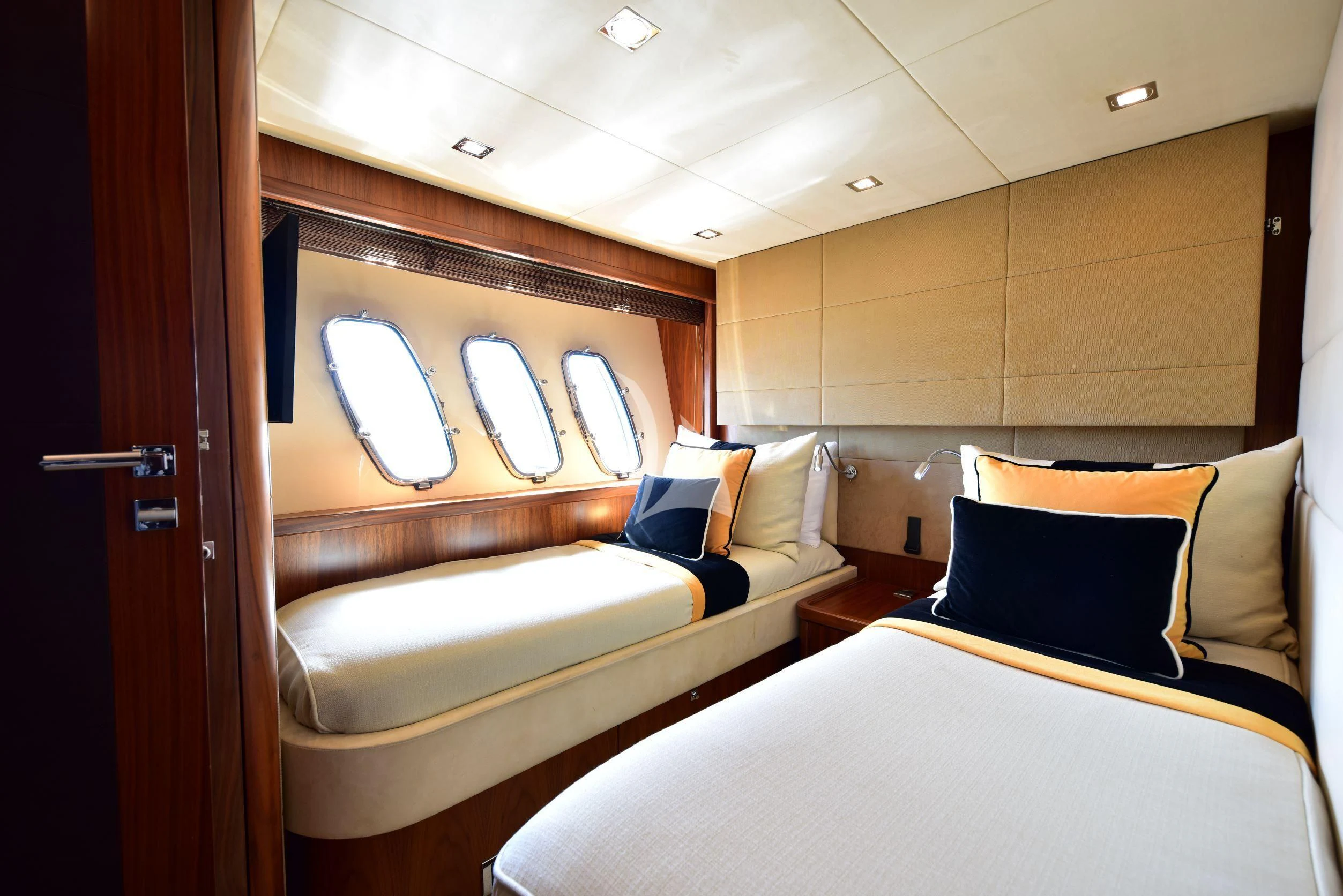a room with beds and a door aboard CATALANA Yacht for Charter