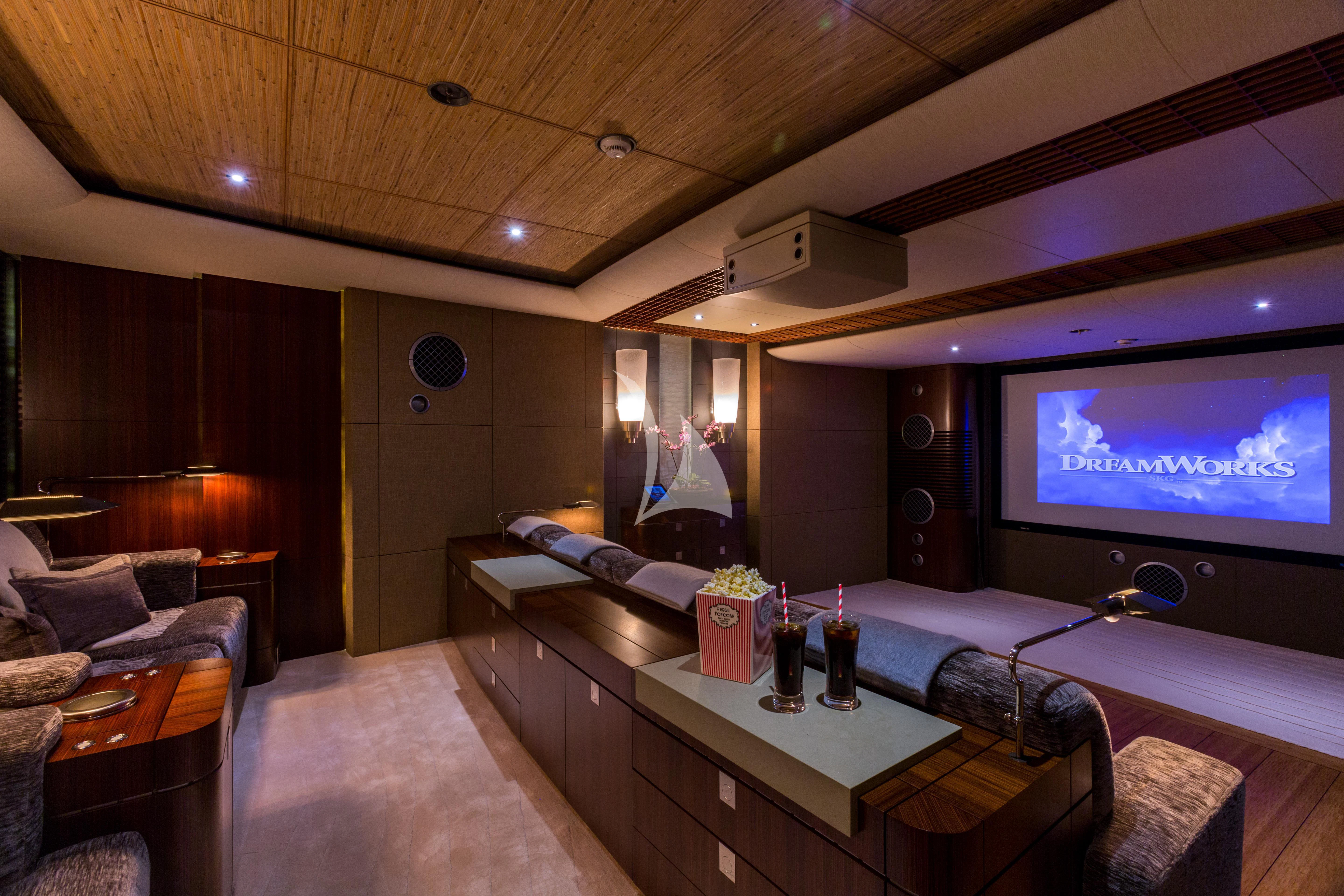 a room with a tv and a table with bottles and chairs aboard WHEELS Yacht for Sale
