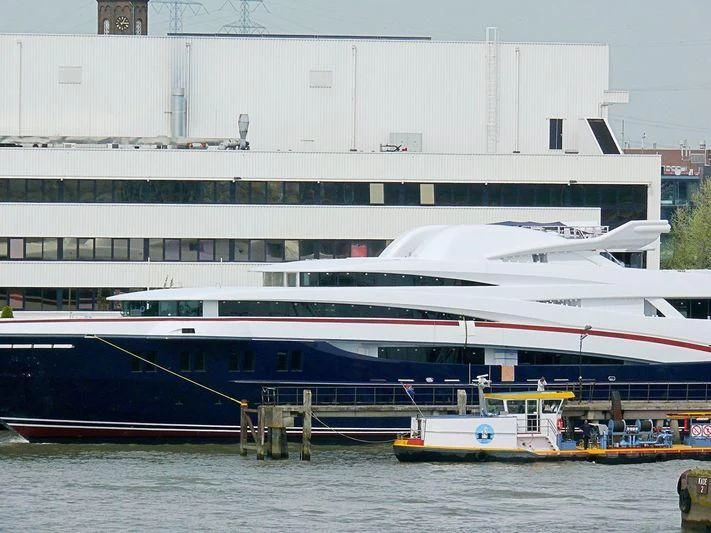 a large white boat sits at a dock aboard WHEELS Yacht for Sale