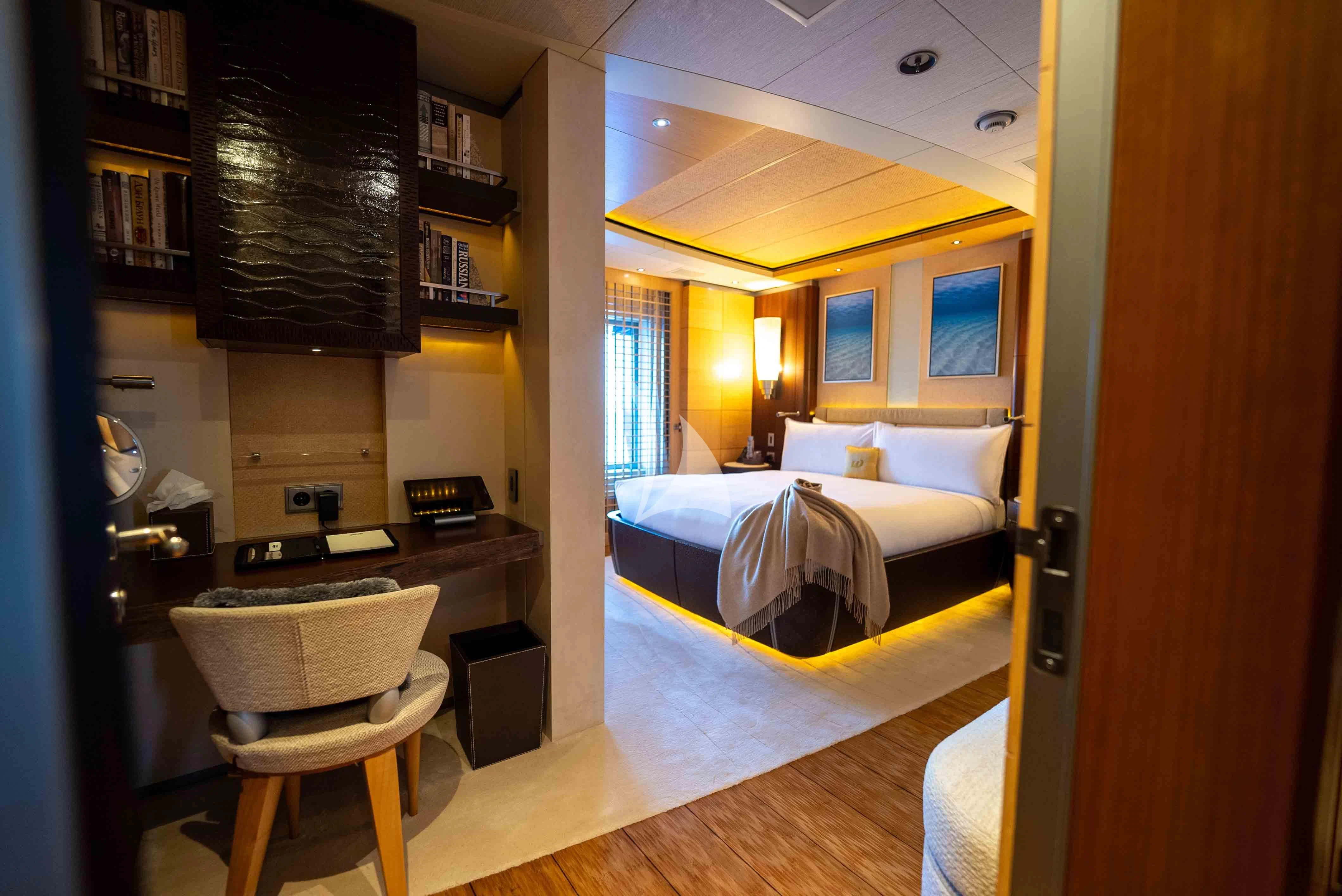 a bedroom with a bed and desk aboard WHEELS Yacht for Sale