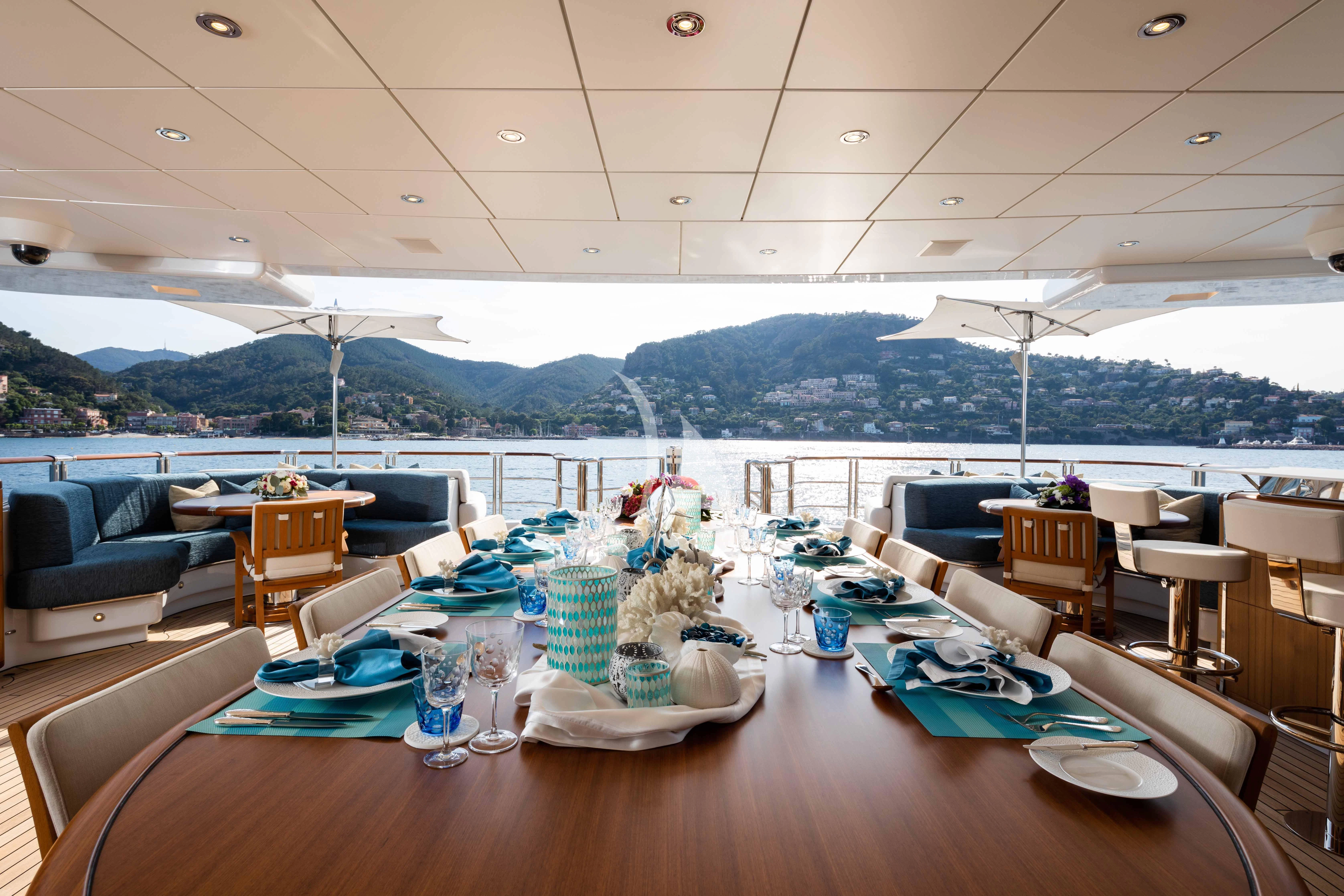 a table with plates and cups on it aboard WHEELS Yacht for Sale