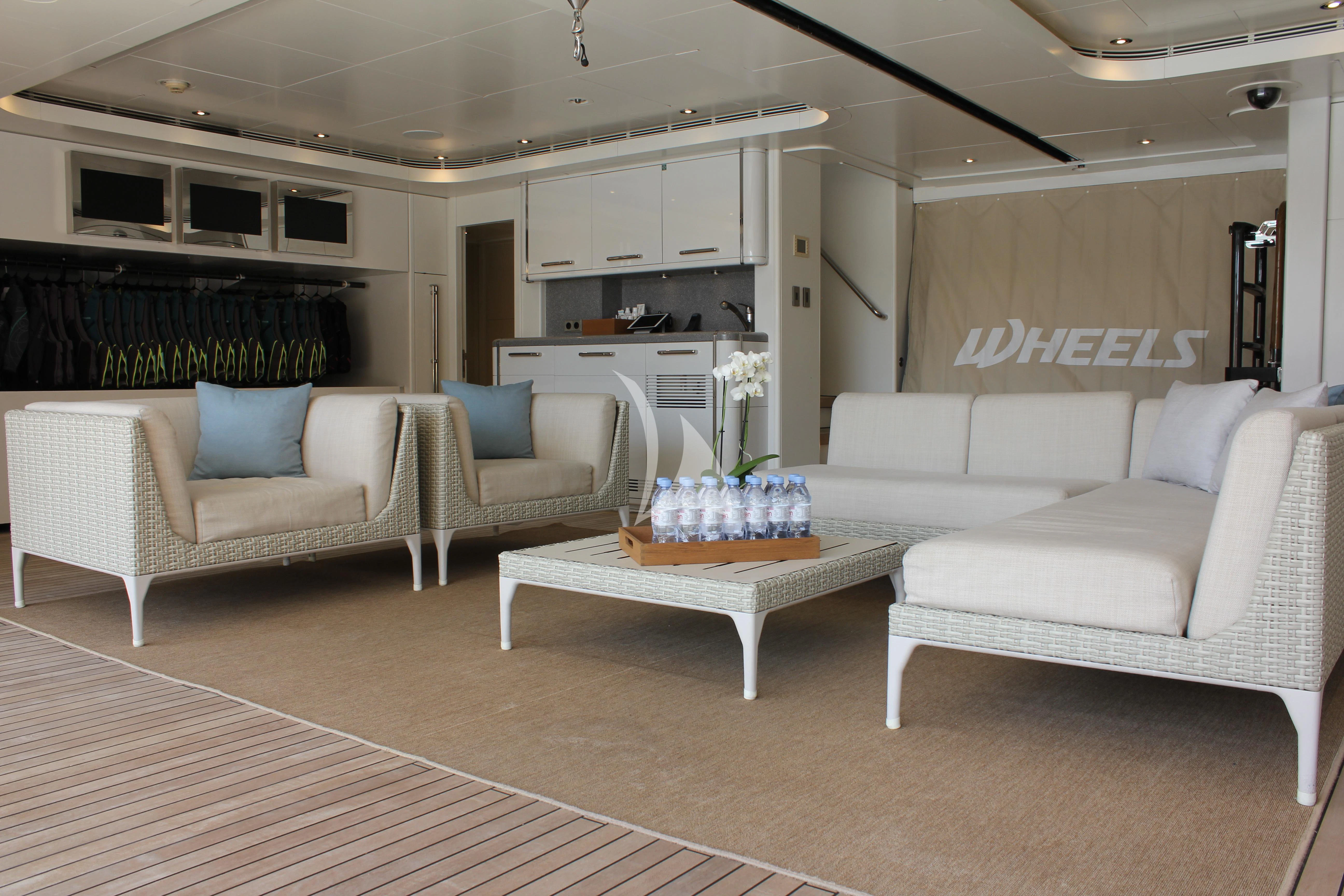 a living room with white couches aboard WHEELS Yacht for Sale