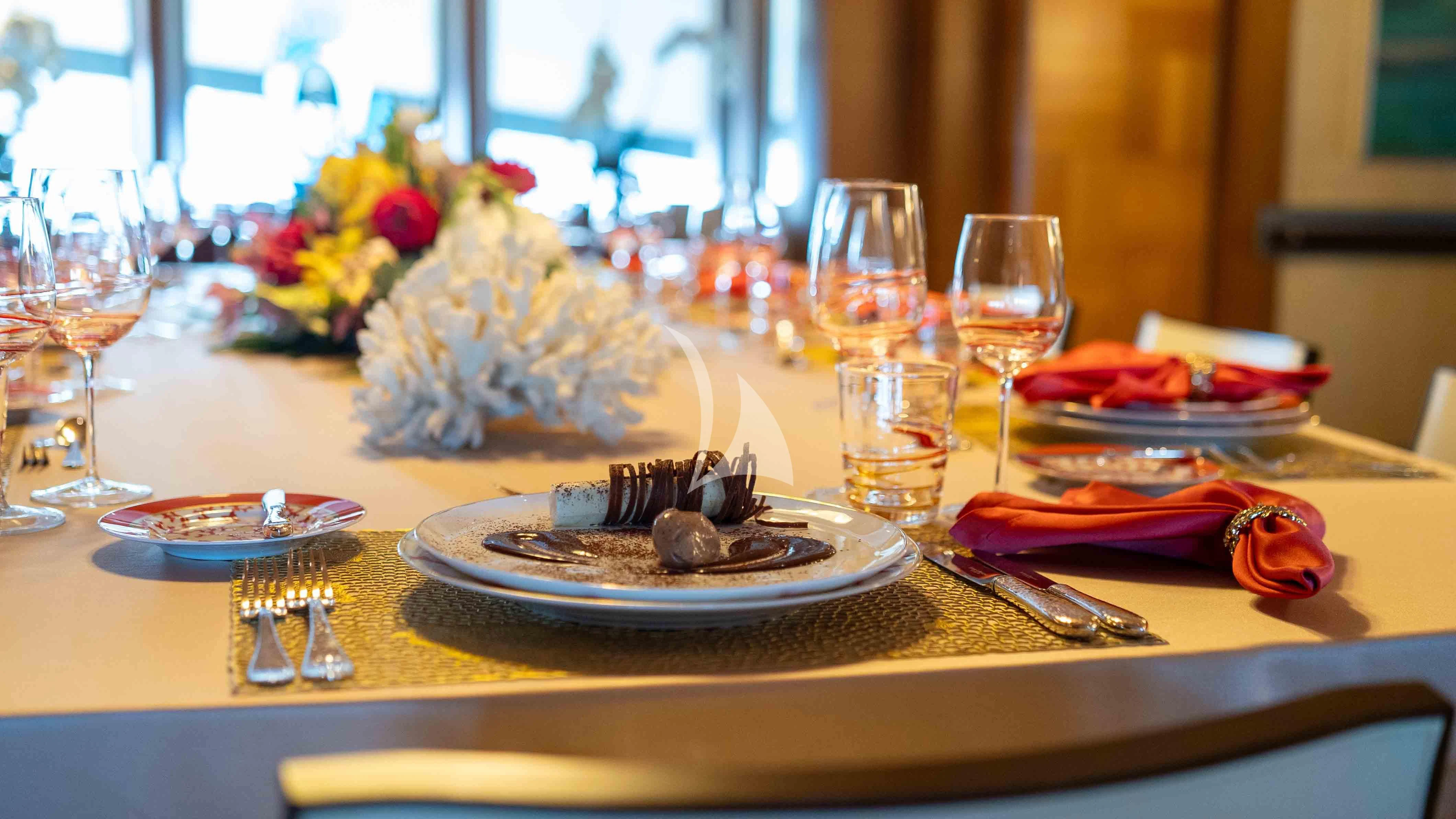 a table with food and glasses aboard WHEELS Yacht for Sale
