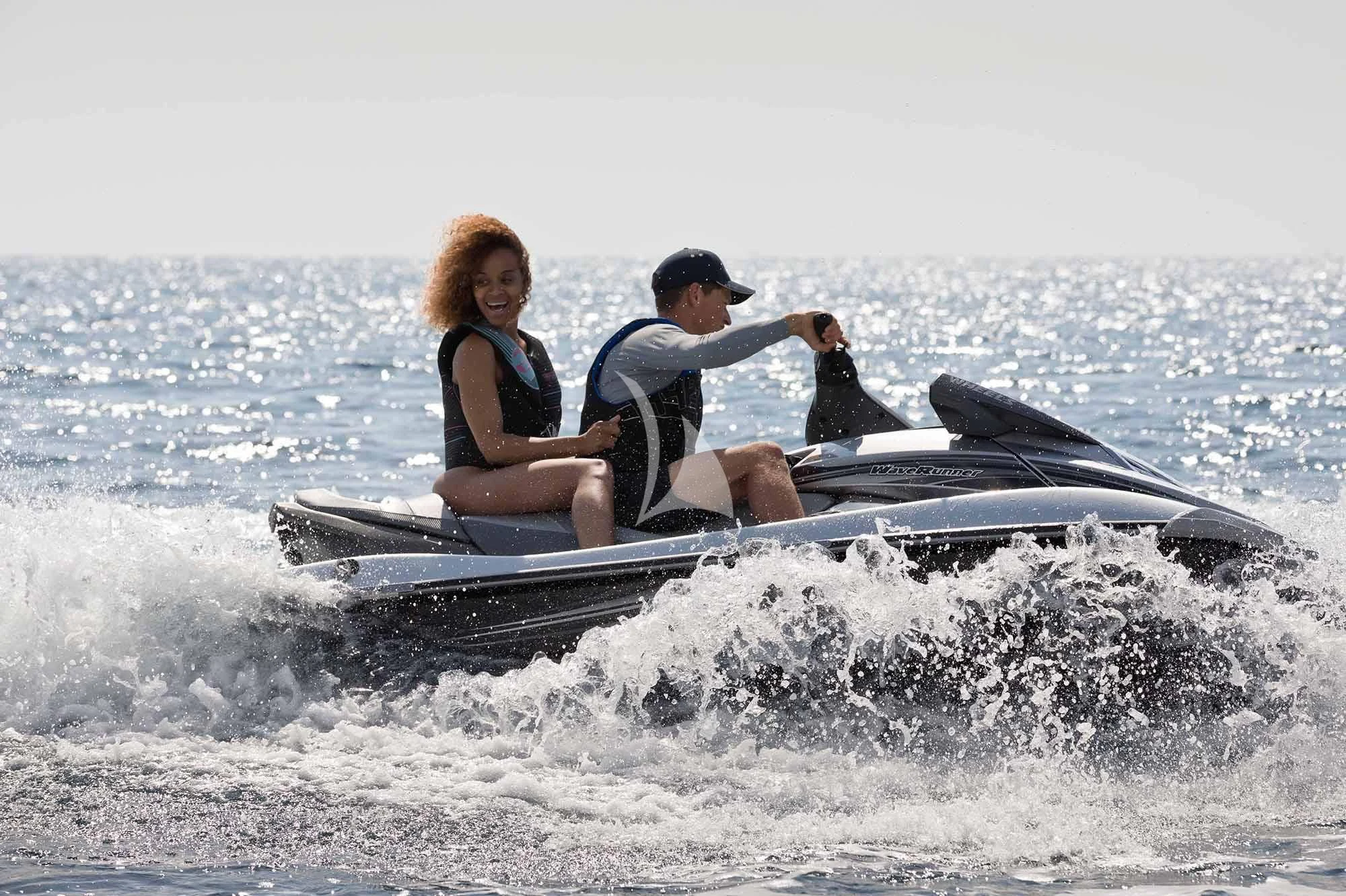 a man and woman on a jet ski in the ocean aboard WHEELS Yacht for Sale
