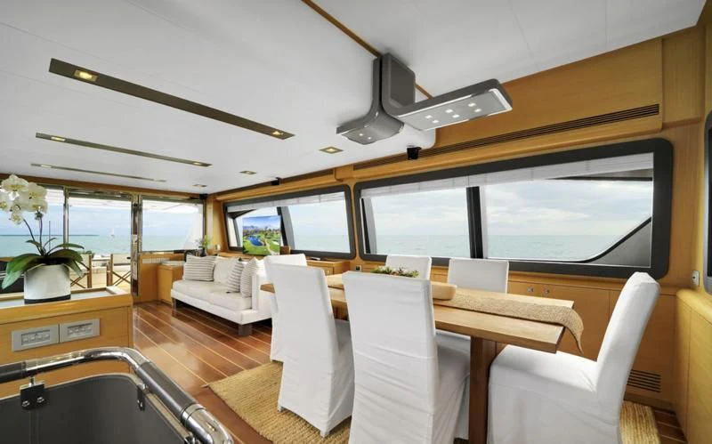 a room with a table chairs and a large window aboard BON BON Yacht for Sale