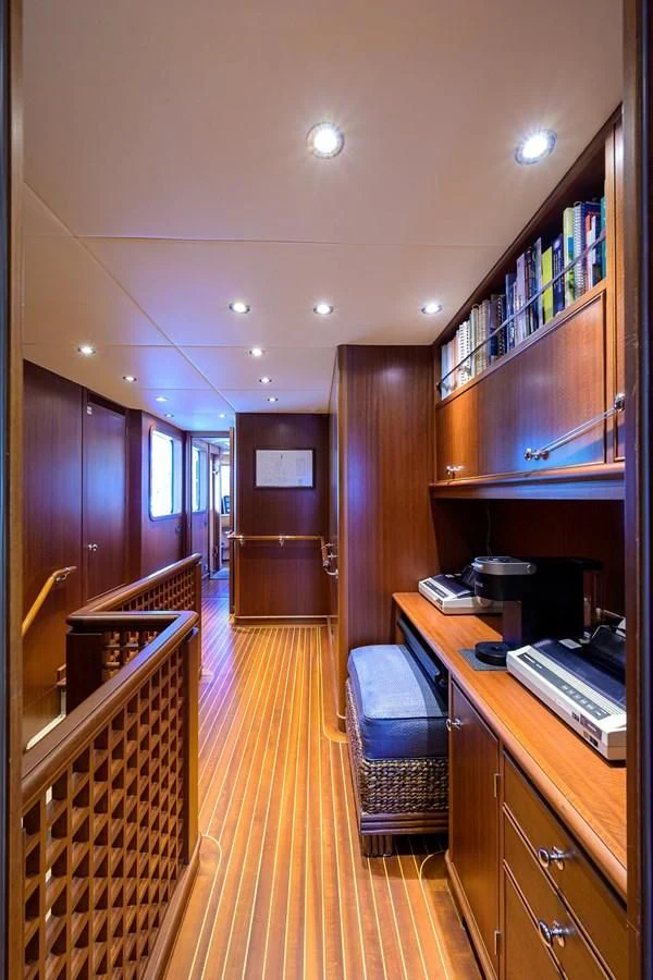 a room with a piano and a book shelf aboard OUR WAY Yacht for Sale