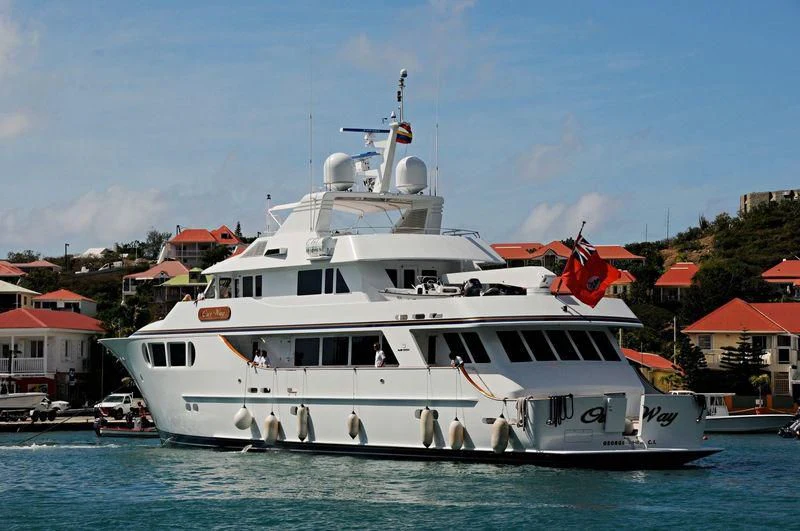 a large white boat in a harbor aboard OUR WAY Yacht for Sale