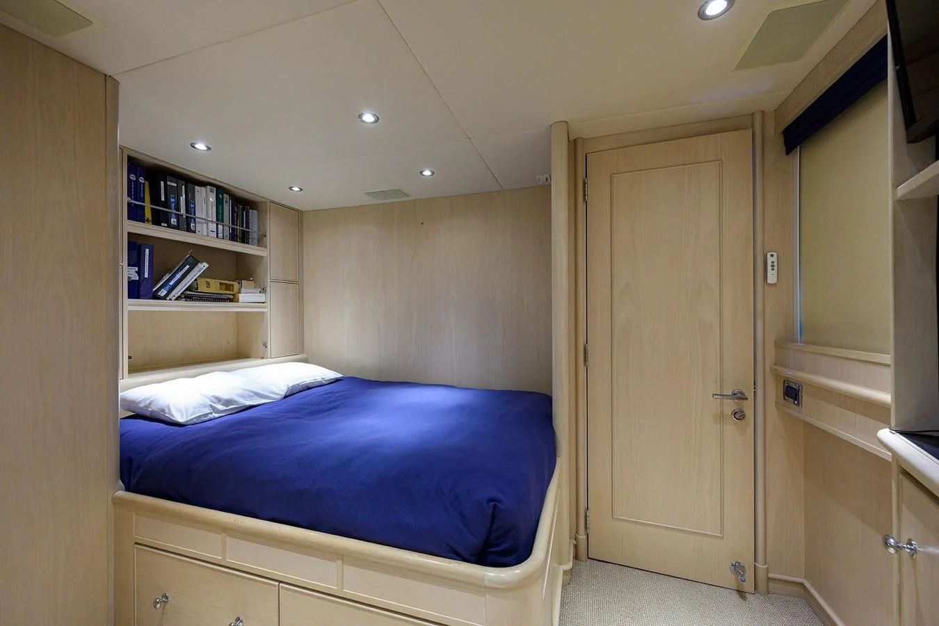 a bedroom with a bed and a bookcase aboard OUR WAY Yacht for Sale