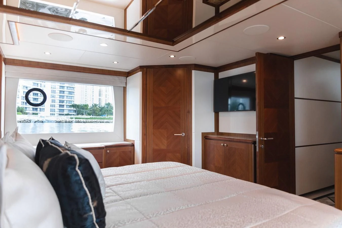 a bedroom with a bed and a wood door aboard OCEAN ROSE Yacht for Sale