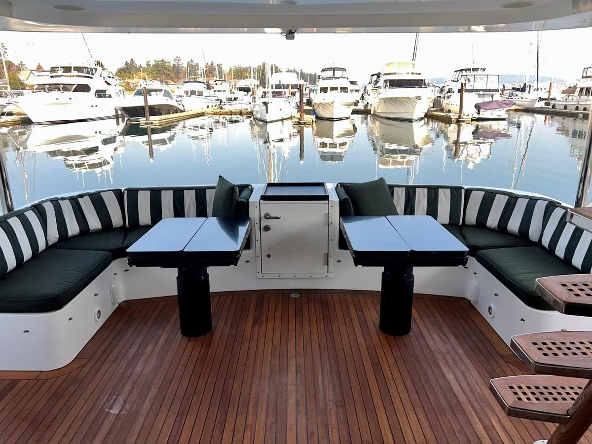 a table with chairs on it next to a body of water aboard OREGON MIST Yacht for Sale
