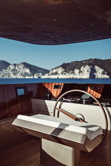 a lounge chair in front of a building with mountains in the background aboard ARTEXPLORER Yacht for Sale