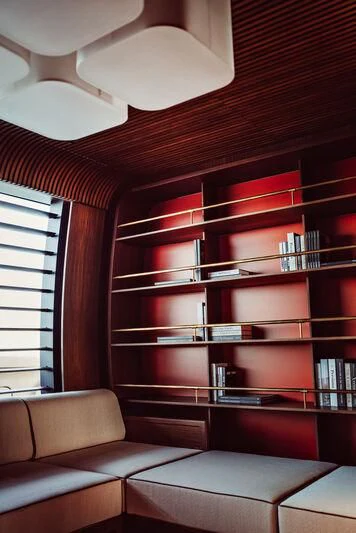 a room with a couch and bookshelves aboard ARTEXPLORER Yacht for Sale