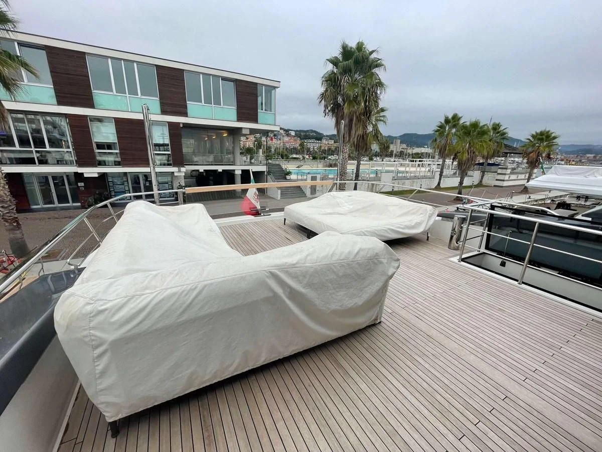 a rooftop with a white sheet over it and a building and palm trees aboard REINE D'AZUR Yacht for Sale