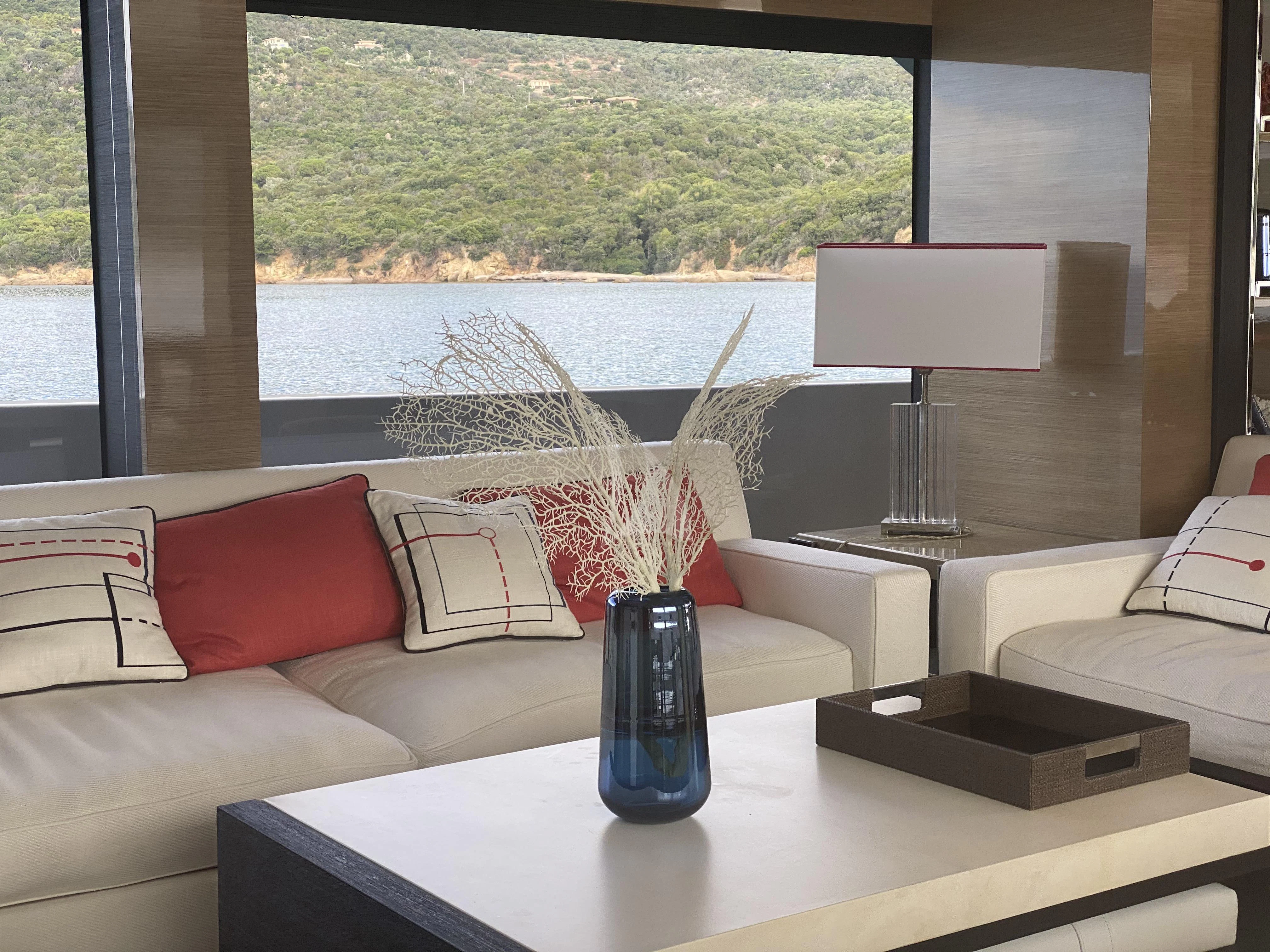 a living room with a glass coffee table and a window aboard REINE D'AZUR Yacht for Sale