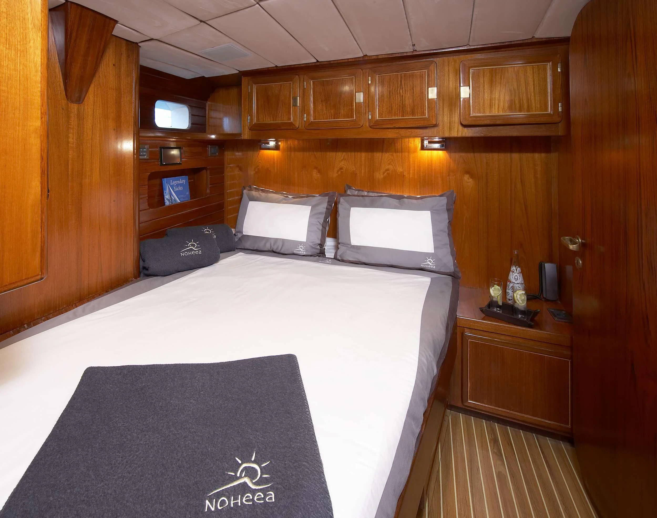 a bed with white sheets aboard NOHEEA Yacht for Sale