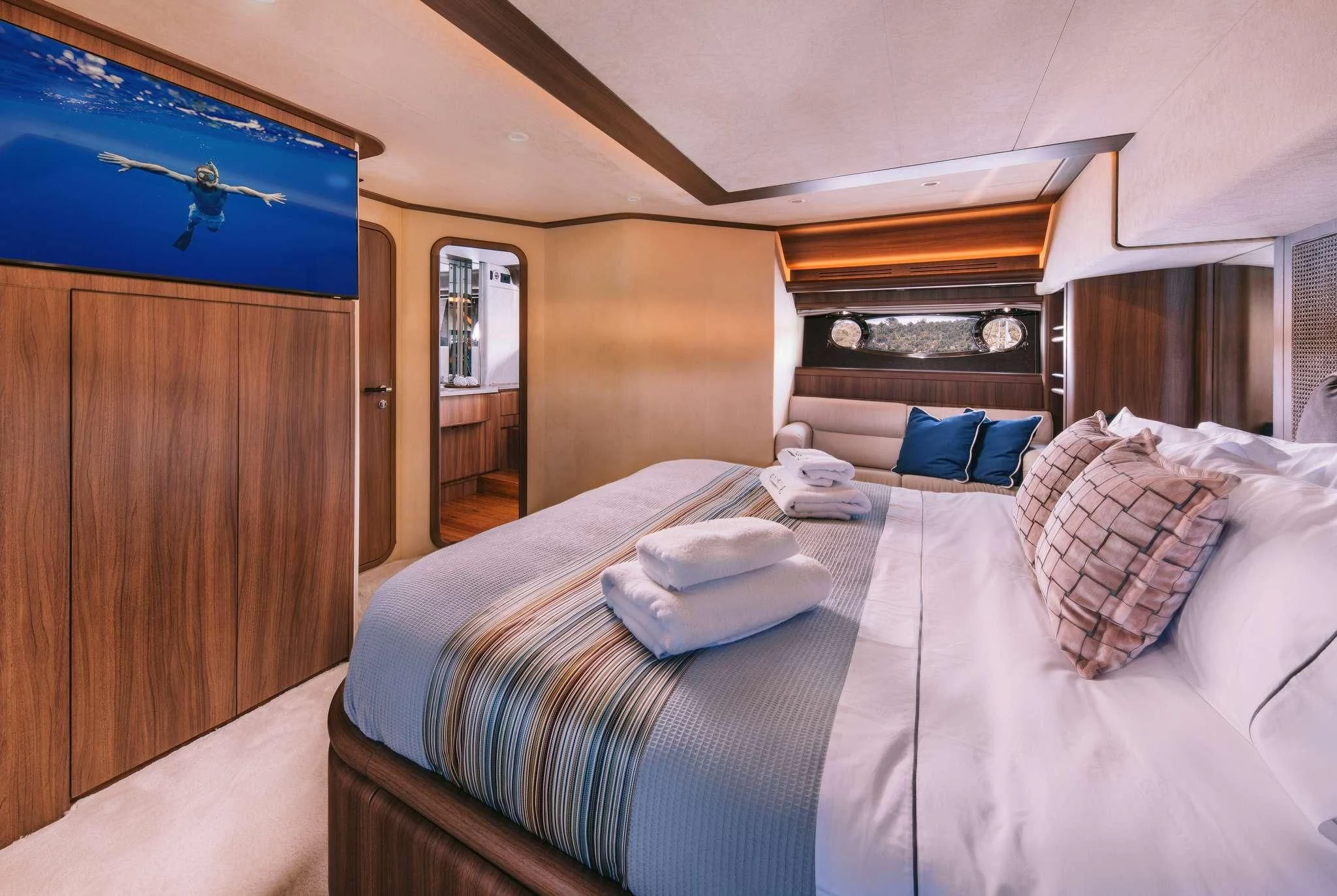 a bed with a blue and white comforter and pillows aboard OXYGEN 8 Yacht for Charter
