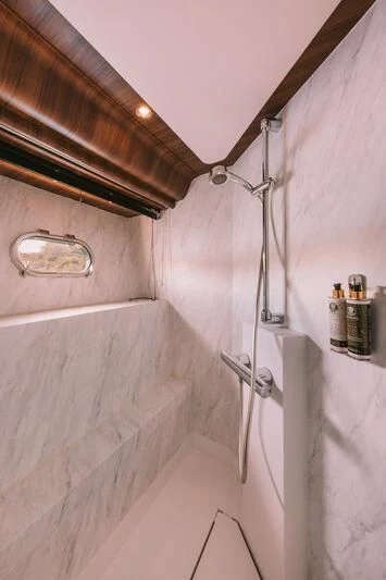 a shower with a sink and a mirror aboard OXYGEN 8 Yacht for Charter