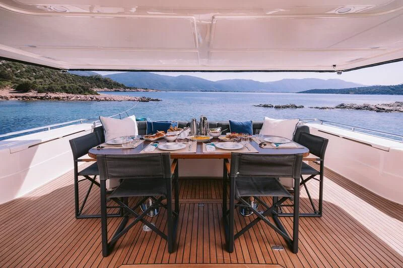 a table set for a meal on a deck overlooking a large body of water aboard OXYGEN 8 Yacht for Charter
