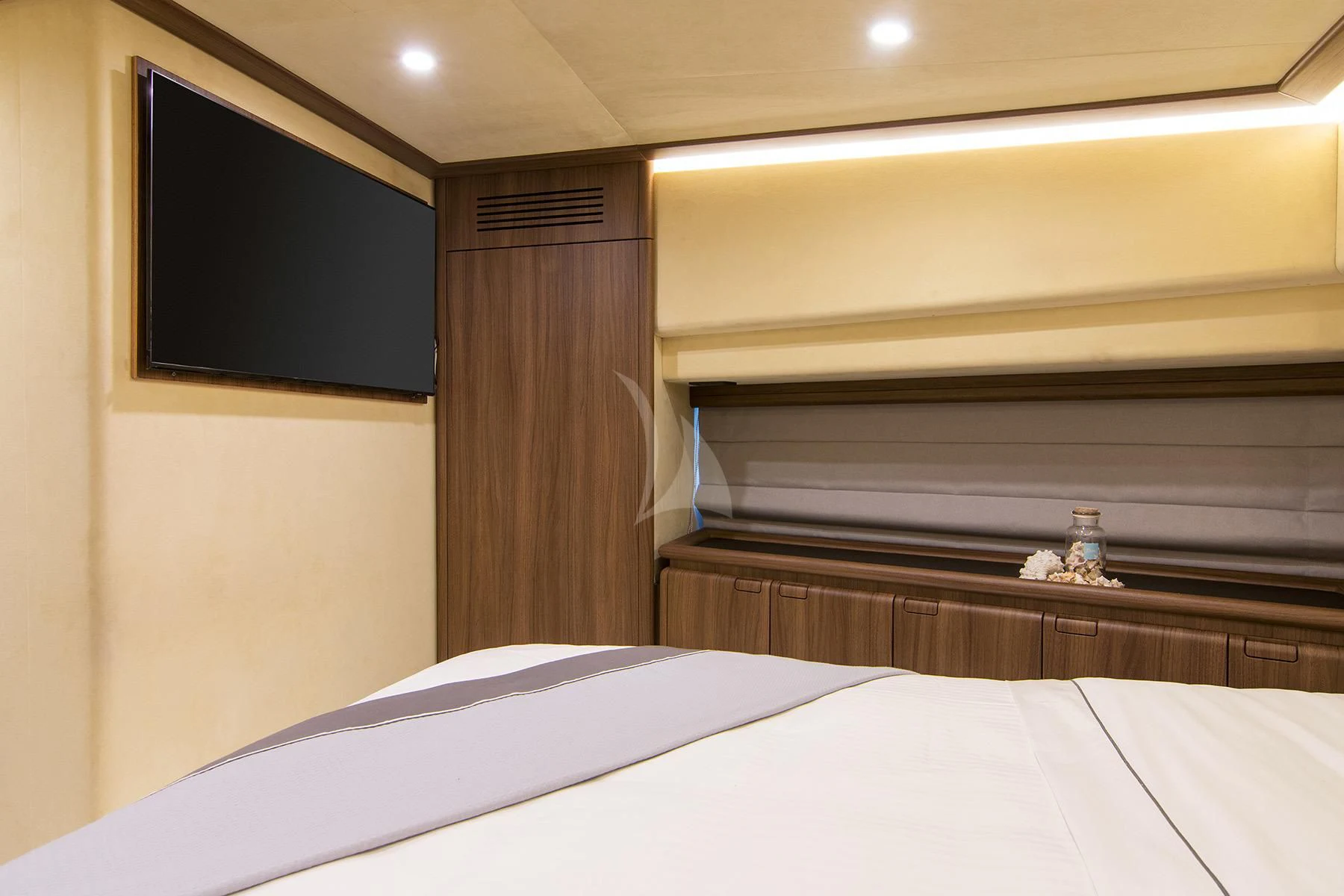 a bed with a white sheet and a black television on the wall aboard OXYGEN 8 Yacht for Charter