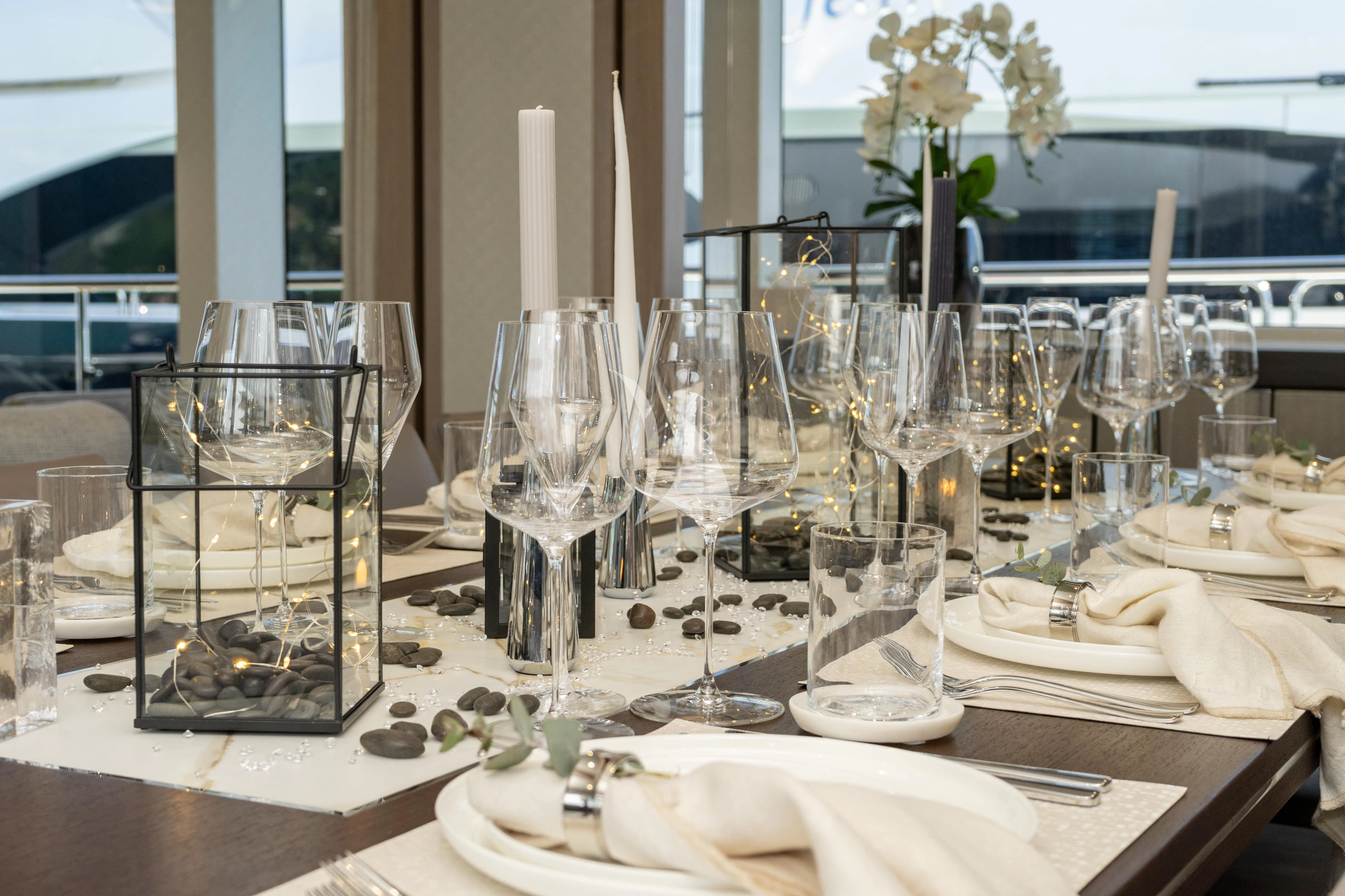 a table with wine glasses and plates aboard SUNSET Yacht for Sale