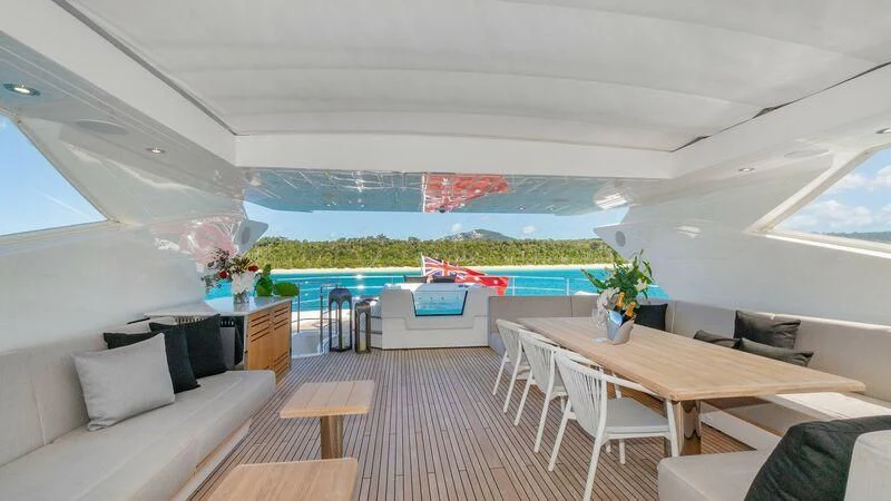 a room with a table chairs and a pool aboard SUNSET Yacht for Sale