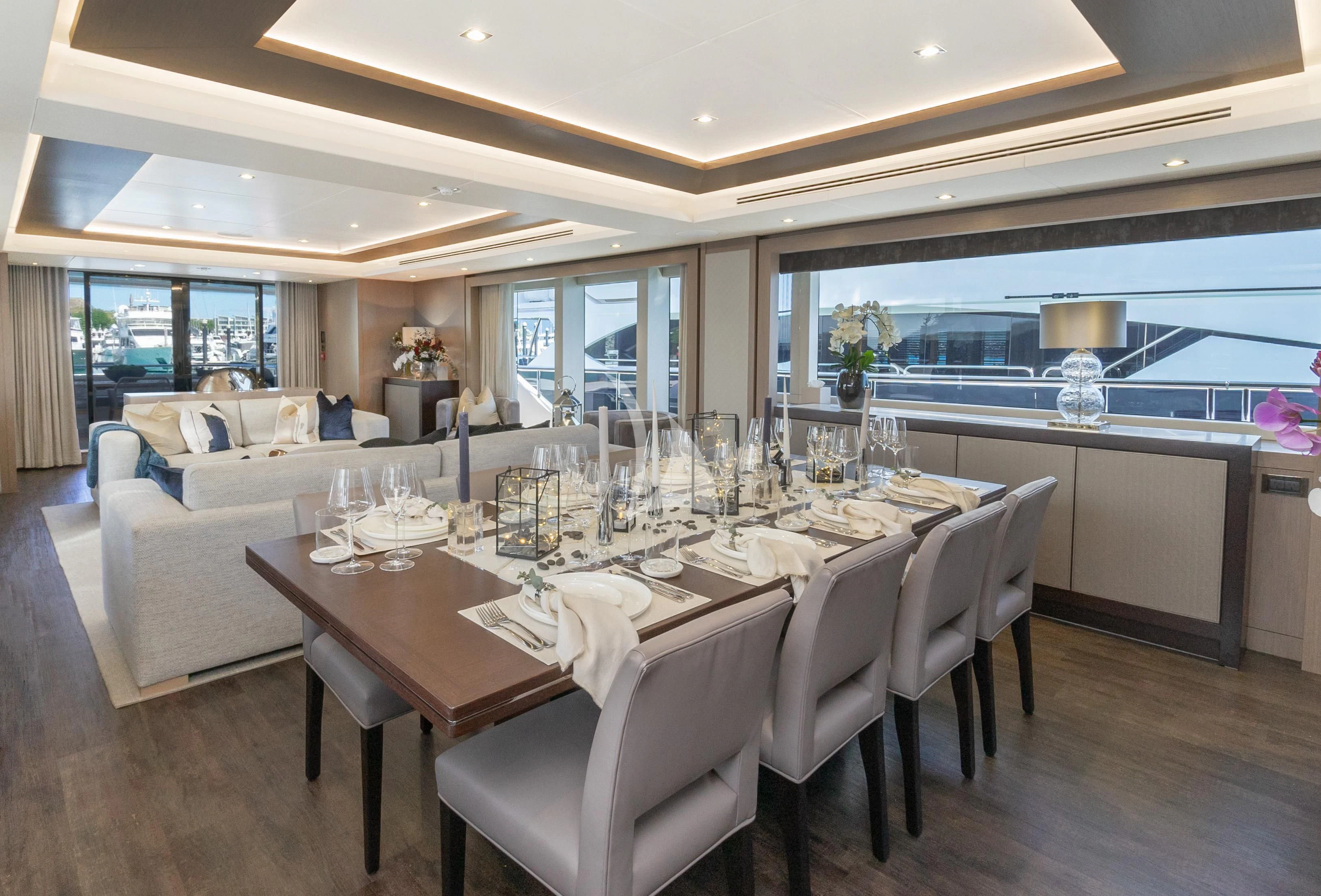 a large dining table with white chairs aboard SUNSET Yacht for Sale