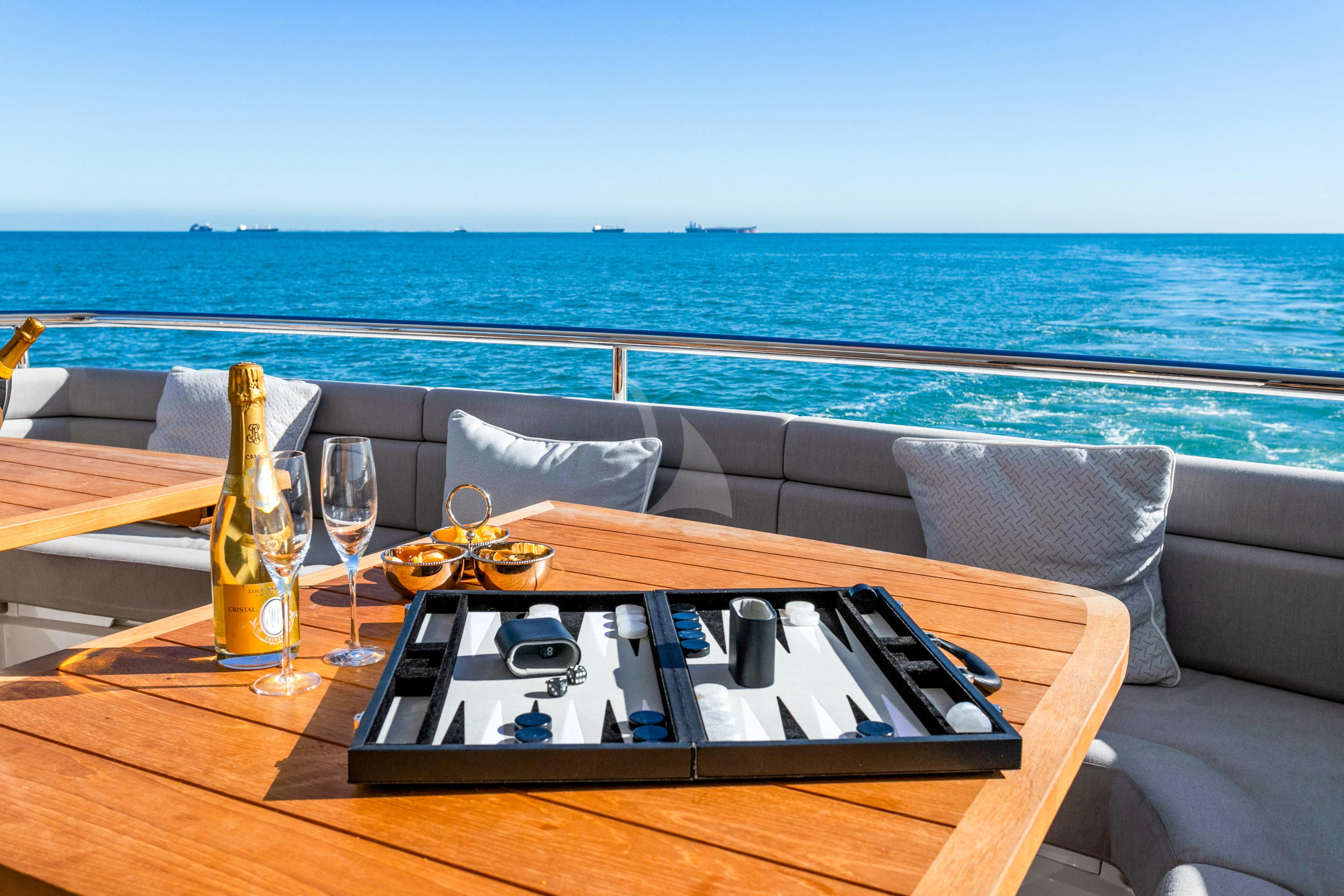 a table with a remote control and a glass of beer on it aboard SUNSET Yacht for Sale